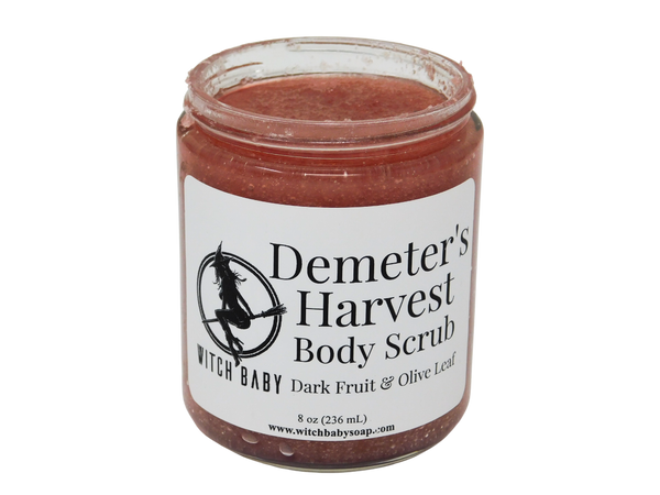 jam colored body scrub in an 8 oz glass jar with a white label that reads: demeter's harvest body scrub. dark fruit & olive leaf.