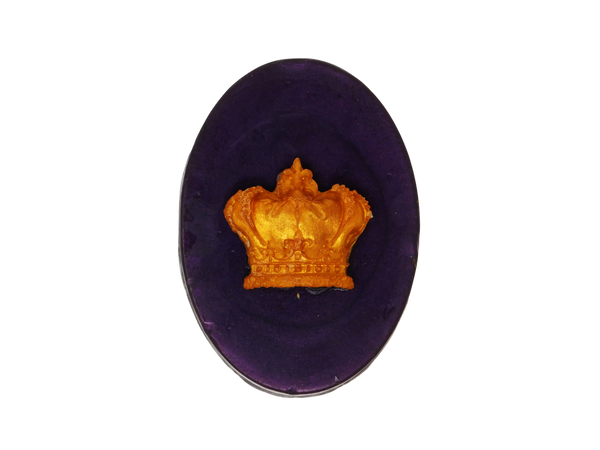 Deep plum colored oval soap with a gold crown on top.