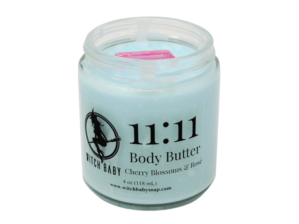 light blue body butter in a 4 oz glass jar with label that reads: 11:11 Body Butter. Cherry Blossoms & Rose.