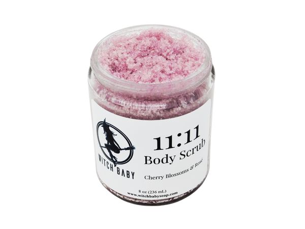 pink sugar scruib packaged in 8 oz glass jar with a white label that reads: 11:11 Body Scrub. Cherry Blossoms & Rose. 