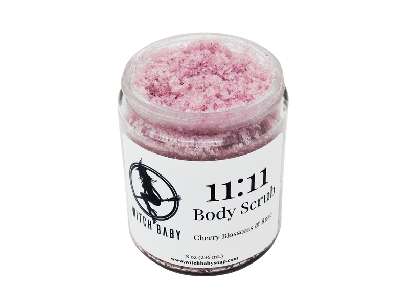 pink sugar scruib packaged in 8 oz glass jar with a white label that reads: 11:11 Body Scrub. Cherry Blossoms & Rose. 