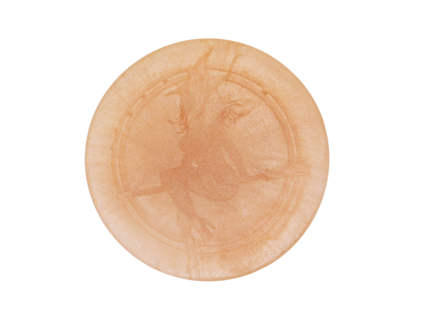circle shaped peach colored soap with the witch baby emblem on it 