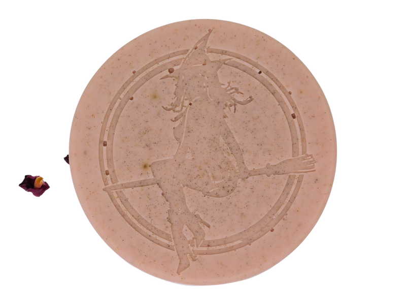pink clay colored soap speckled with herbs with Witch Baby logo on top