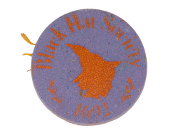 circular purple bath bomb with an autumn orange glitter airbrush of a witch's side profile surrounded by text that says black hat society 1692