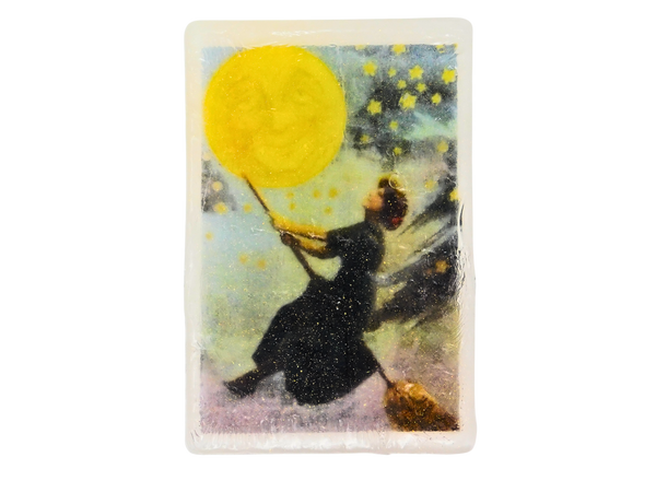 Bar of soap with an illustration of a person in a night dress holding a moon with stars around, against a white background.