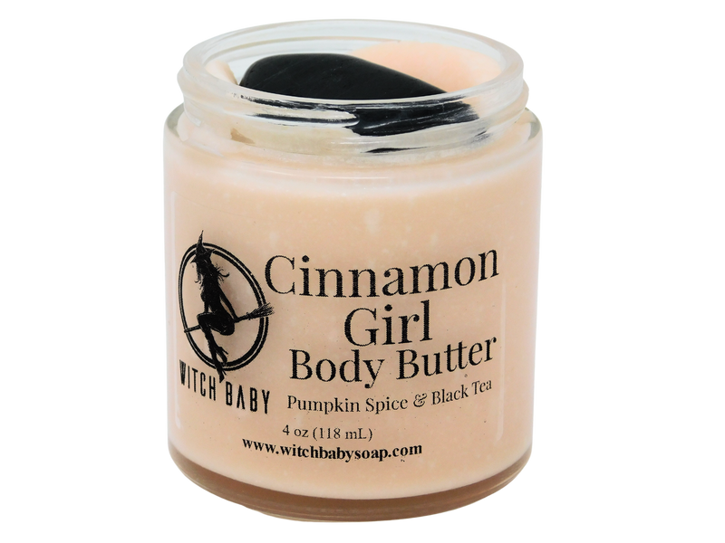 4 oz glass jar filled with autumnal orange body butter and topped with black tourmaline. Clear label reads: Cinnamon Girl Body Butter. Pumpkin Spice & Black Tea. 