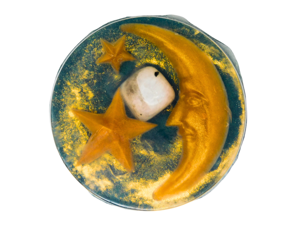 circular forest green soap with gold stars and moons, a crystal, and gold glitter
