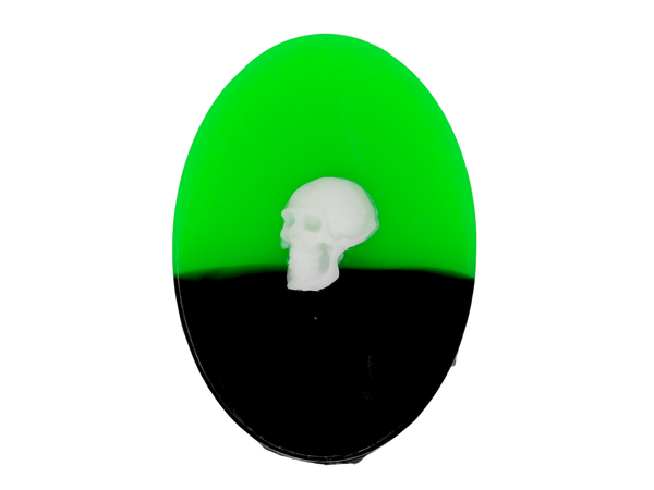Half neon green half black oval soap with white skull embellishment on top