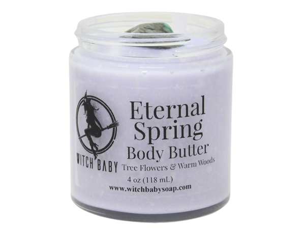 purple body butter in glass jar with clear label that reads: eternal spring body butter. tree flowers & warm woods. 
