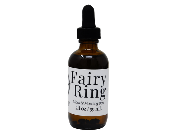 brown glass bottle of body oil that says fairy ring. moss& morning dew. 
