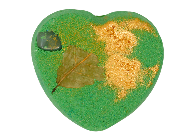 green heart shaped bath bomb with gold glitter, a bay leaf, and tumbled green aventurine on top
