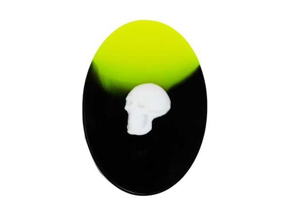 neon yellow and black oval soap with white skull on top