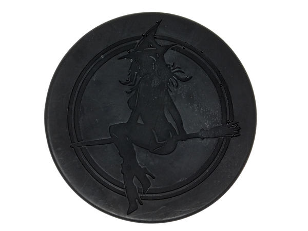 Circular black soap with witch baby logo on top