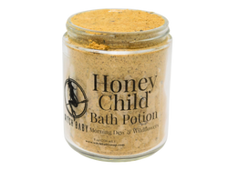 8 oz glass jar filled with dark yellow bath potion with a clear label that reads: Honey Child Bath Potion. Morning Dew & Wildflowers.