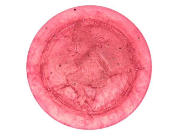 pink circular soap withi black seeds and witch baby logo on top