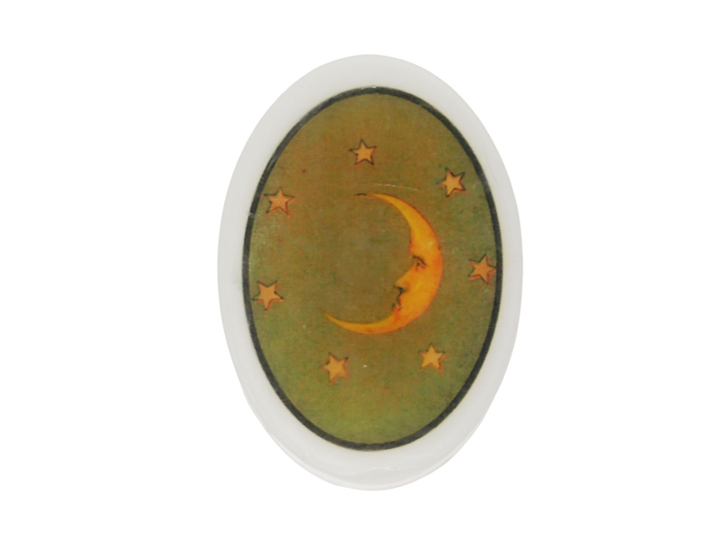 oval soap with a moon and stars on an olive green background