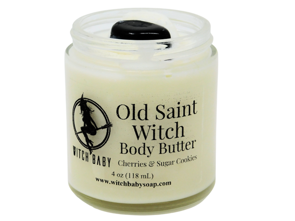 white body butter in  4 oz glass jar topped with snowflake obsidian. clear label reads: Old Saint Witch Body Butter. Cherries & Sugar Cookies. 