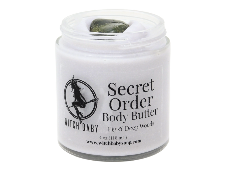 2 oz glass jar filled with light lavender colored body butter topped with labradorite. Clear label reads: Secret Order Body Butter. Fig & Deep Woods.
