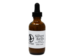 2 oz glass dropper bottle with white label that reads: silver bells body oil. candy cane & winter woods.