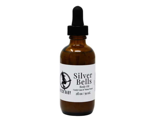 2 oz glass dropper bottle with white label that reads: silver bells body oil. candy cane & winter woods.