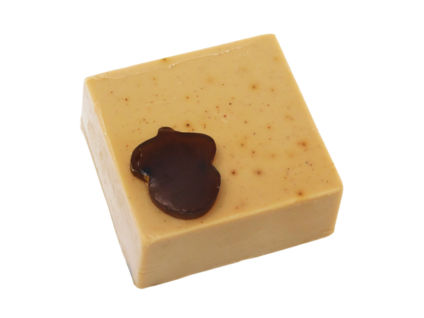 side view of light brown coffee speckled square soap  with dark brown acorn shaped soap on top