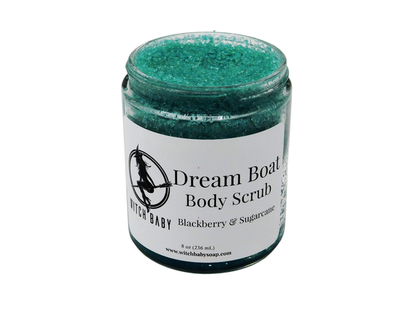 aqua blue granular scrub in a glass 8 oz jar with a white label that reads: Dream Boat Body Scrub. Blackberry & Sugarcane. 