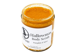 Pumpkin puree colored scrub speckled with pumpkin spice and exfoliating salt granules in a gl;ass 8 oz jar (236 mL). White label reads: Hallowmas Body Scrub . Pumpkin & Spice.