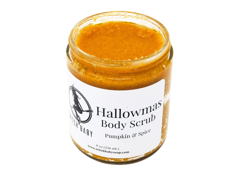 Pumpkin puree colored scrub speckled with pumpkin spice and exfoliating salt granules in a gl;ass 8 oz jar (236 mL). White label reads: Hallowmas Body Scrub . Pumpkin & Spice.