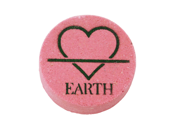 pink circular bath bomb with the symbol of the earth element (but fashioned to be a heart instead of a triangle) and the word EARTH airbrushed at the bottom in dark green glitter