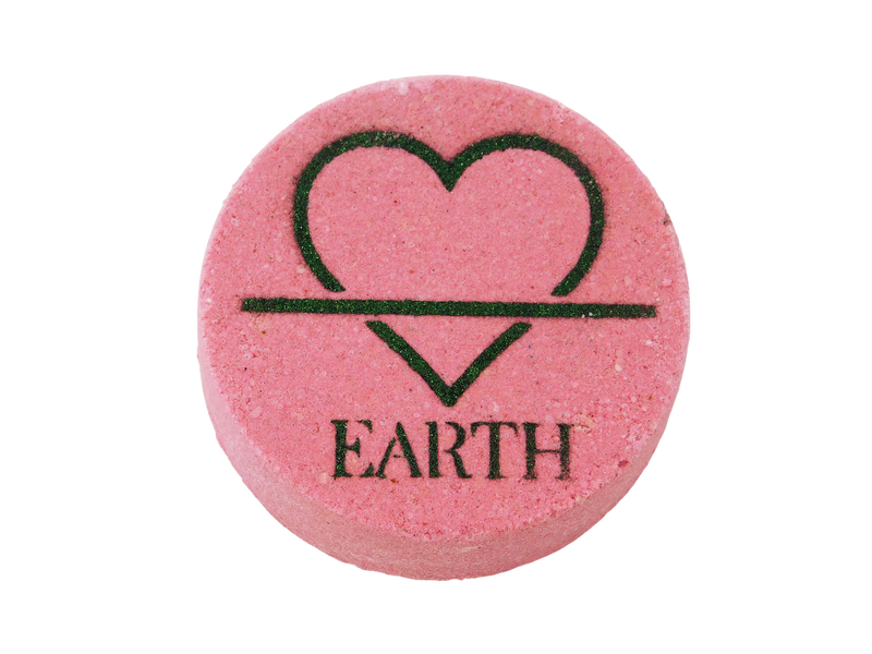 pink circular bath bomb with the symbol of the earth element (but fashioned to be a heart instead of a triangle) and the word EARTH airbrushed at the bottom in dark green glitter