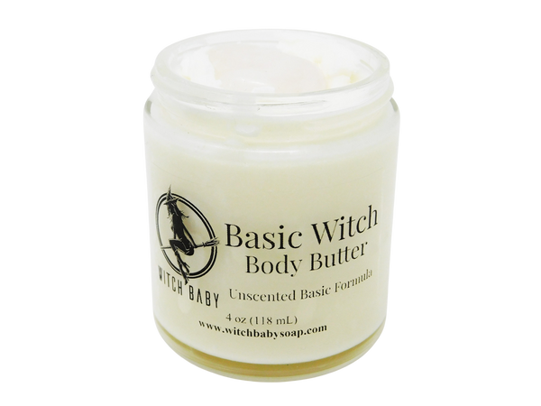 4 oz glass jar containing white body butter topped with milk quartz. Label says unscented basic formula. 