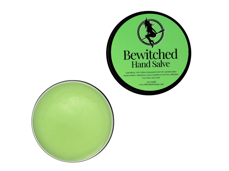 2 oz black tin of Bewitched Hand Salve with green label pictured with the lid off to show the green hand salve inside 