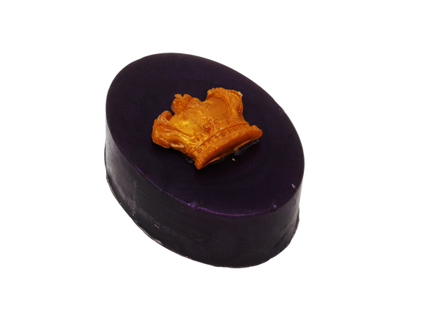 Side view of deep plum colored oval soap with a gold crown on top.