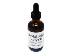2 oz brown glass dropper bottle with white label that reads: Crystal Baller Body Oil. Heliotrope & Oud. 
