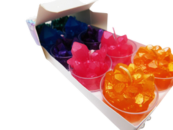 Crystal shaped candles inside of small plastic container. Green, blue, purple, pink, and orange pictured. 