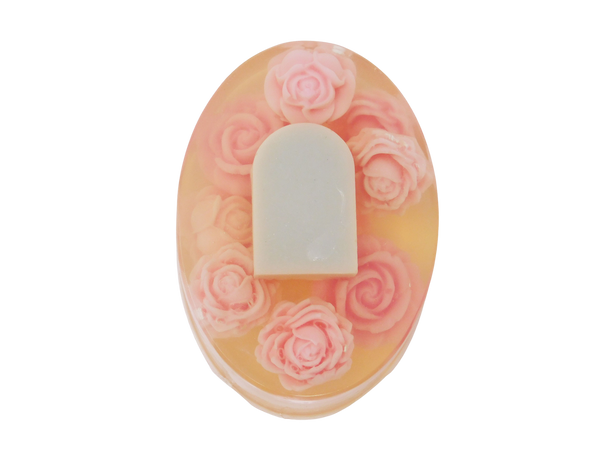 Oval shaped soap with tombstone and rose design. Roses are pink and tombstone is grey. 