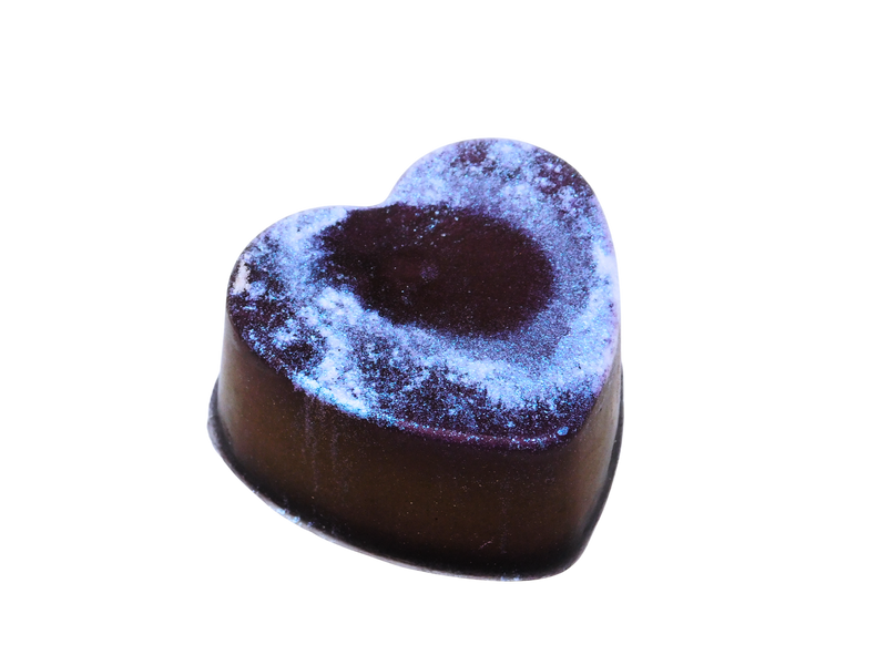 side view of dark purple heart soap splattered with iridescent glitter 
