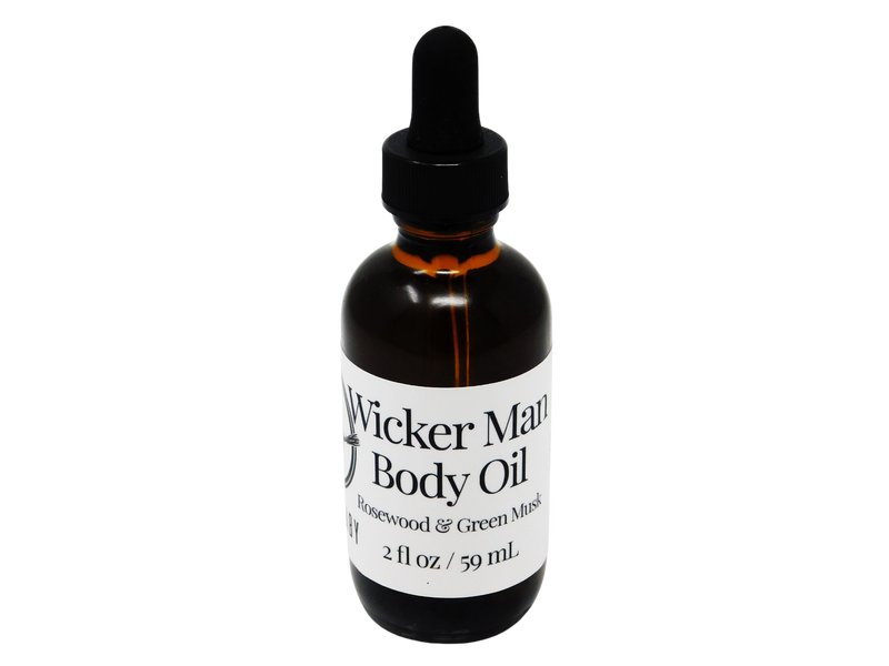2 oz brown glass dropper bottle with white label that reads: Wicker Man Body Oil. Rosewood & Green Musk.
