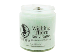 A sage green colored body butter packaged in a 4 oz glass jar with a label that reads: Wishing Thorn Body Butter. Blackthorn & Wild Sage.