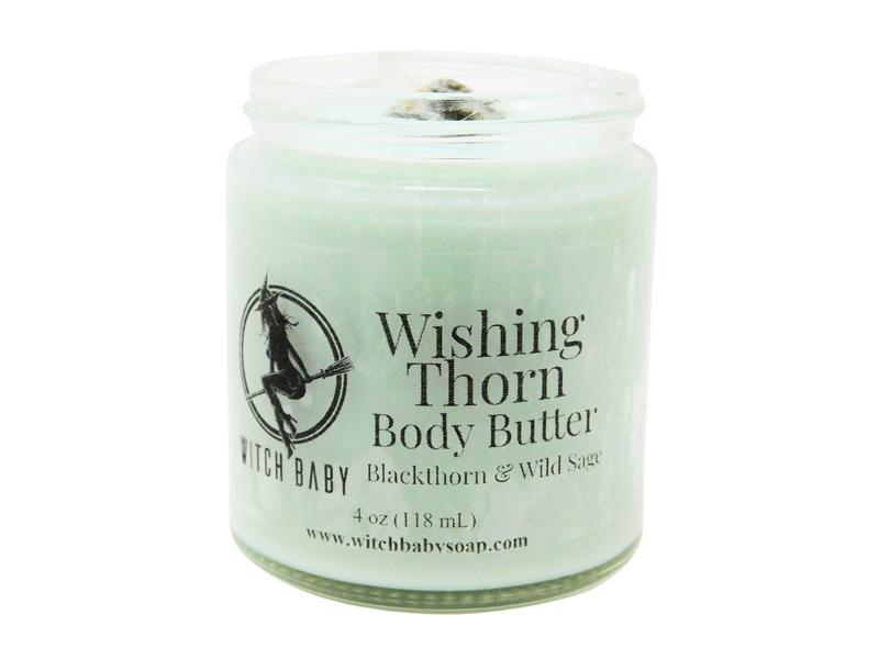 A sage green colored body butter packaged in a 4 oz glass jar with a label that reads: Wishing Thorn Body Butter. Blackthorn & Wild Sage.