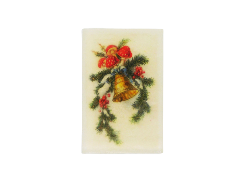 A rectangle shaped glycerin soap that smells like snow covered juniper trees, blackberry mead, cocoa, and peppermint, and has a vintage yuletide christmas holiday greeting card image of a mushroom and winter foliage covered bell with snow on it.